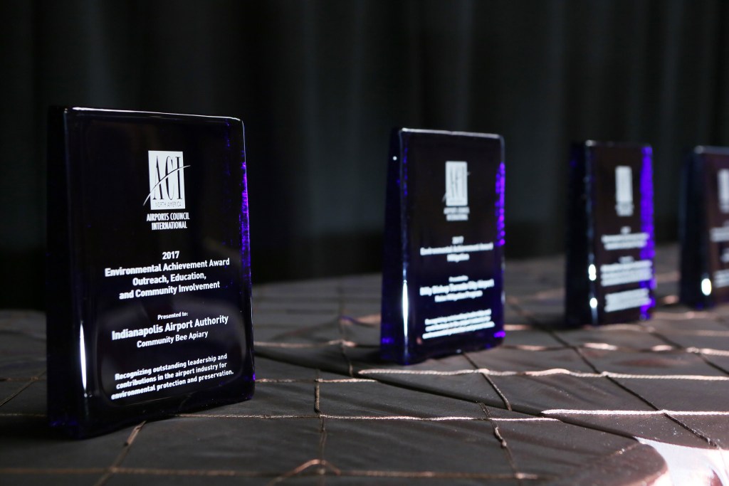 Environmental Achievement Awards ACI-NA's Environmental Achievement Awards glass awards in a row on a table