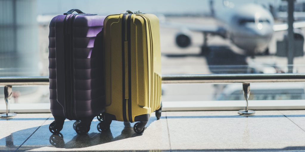 Suitcases in front of airplanes at airport gate